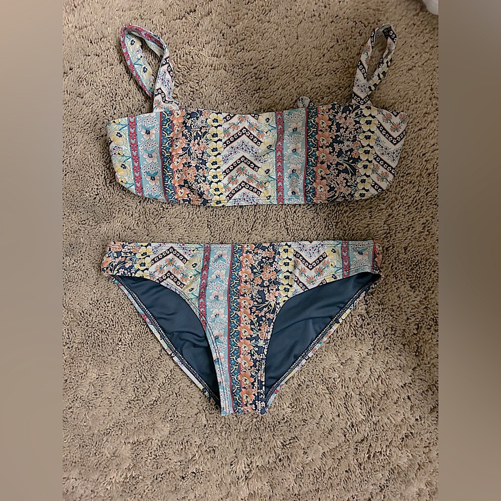 A two piece bikini with floral and patterns throughout the baiting suit